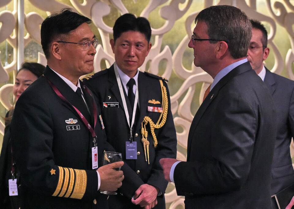 Adm. Sun Jianguo, left, from the Chinese People's Liberation Army Navy, chats with US Secretary of Defense Ashton Carter, right, during the ministerial luncheon at the 14th Asia Security Summit in Singapore on May 30. (AFP Photo/Roslan Rahman)
