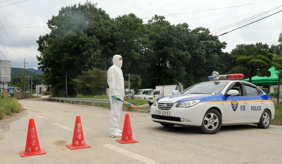 This picture taken on June 5 shows South Korean police and health officials blocking a road to a village after it was confirmed there was one MERS case in the village in Sunchang, 240 kilometers south of Seoul. (AFP Photo/Yonhap)