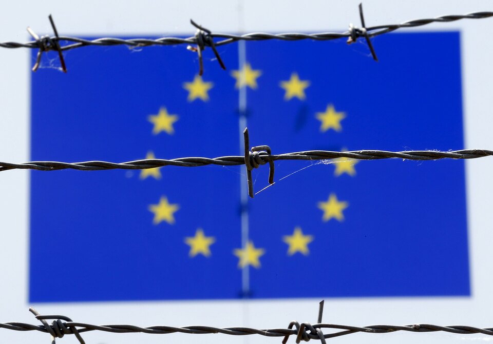 A barbed wire is seen in front of a European Union flag at an immigration reception center in Bicske, Hungary June 25, 2015. (Reuters Photo/Laszlo Balogh)