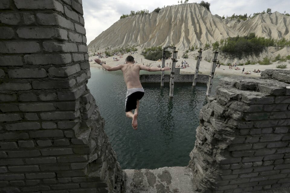 A man jumps into water from the roof of an abandoned Soviet-era prison in Rummu quarry, Estonia, during hot weather on July 4. The country’s president, Toomas Ilves, says he doesn’t like to dwell on the supposed Russian threat to his country after Vladimir Putin’s annexation of Crimea, and is focused instead on turning tiny Estonia into a digital pioneer. (Reuters Photo/Ints Kalnins)