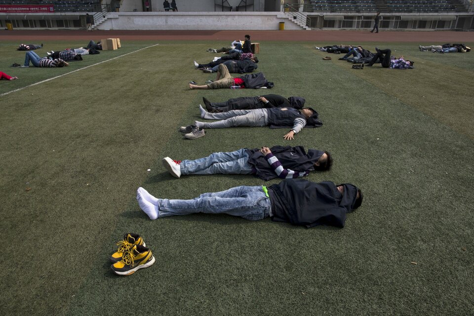 Workers take a nap during lunch break at a Foxconn factory in the township of Longhua in Shenzhen, Guangdong province in this January 21, 2015 file photo. (Reuters Photo/Tyrone Siu)