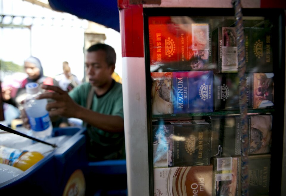 A vendor sells cold drinks and cigarettes near Monas, the National Monument, in Jakarta on July 21, 2015. (Reuters Photo/Darren Whiteside)