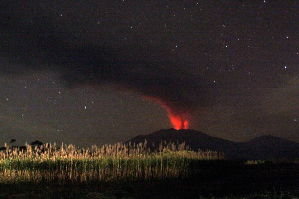 In this long time exposure taken before dawn on July 12, 2015, the 3,300-metre (10,800-foot) Mount Raung volcano emits a column of ash, lava and steam as seen from Banyuwangi, located in eastern Java island. Ash spewing from the Indonesian volcano closed the airport again on neighboring Bali on July 12 just a day after it reopened, causing fresh travel chaos for weary holidaymakers stranded on the resort island.  (AFP Photo)