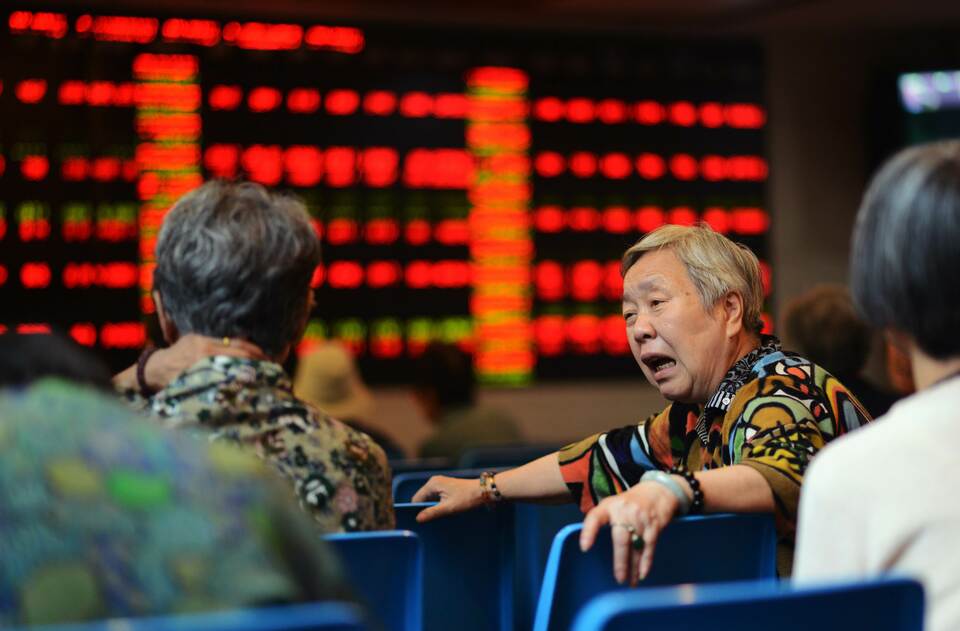 A stock investor reacts in front of a screen showing stock market movements in a brokerage house in Shanghai on July 6, 2015.  (AFP Photo/Johannes Eisele)