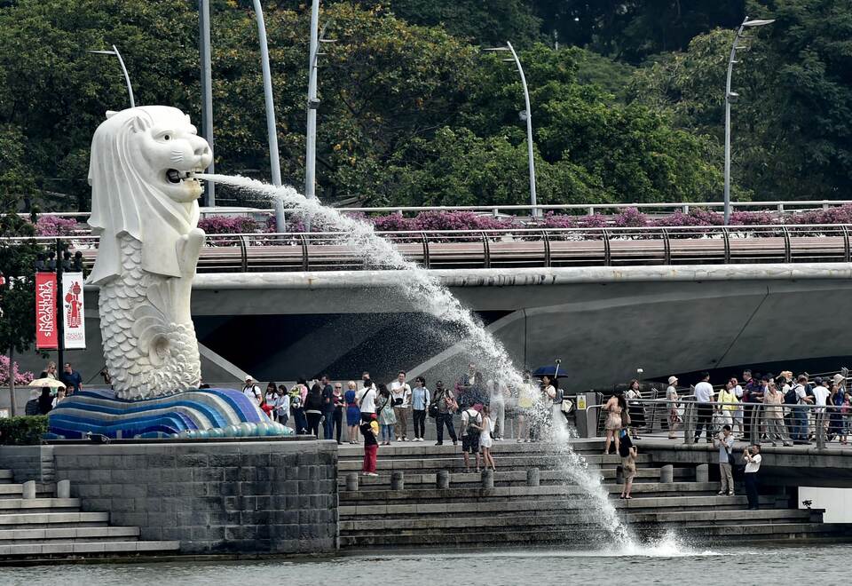 Visitors gather around the iconic Merlion statue for photographs at the Marina bay waterfront in Singapore on August 13, 2015. (AFP Photo/Roslan Rahman) 