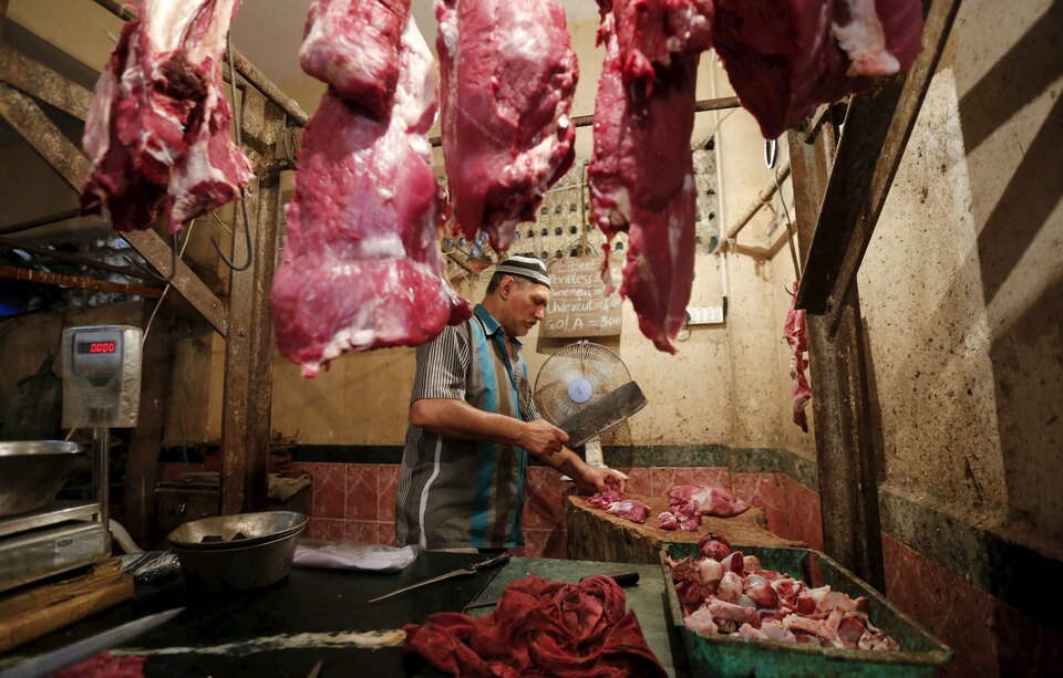 A butcher cuts meat for a customer inside his shop in Mumbai. (Reuters Photo/Shailesh Andrade)