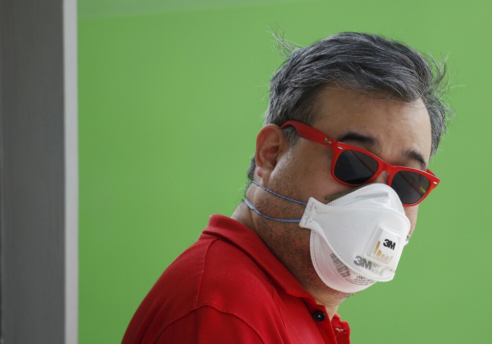 A man wears a mask for protection against the haze as he waits at a polling station during the general election in Singapore. The thick haze from Indonesia's Sumatra and Kalimantan islands has forced the repeated cancellation of flights in the area and pushed air quality to unhealthy levels in neighboring Singapore and Malaysia. (Reuters/Edgar Su)