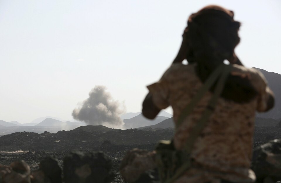 A soldier looks at smoke billowing from the site of a Saudi-led air strike on a Houthi position in the Yemeni frontline province of Marib September 15, 2015. (Reuters Photo/Stringer)