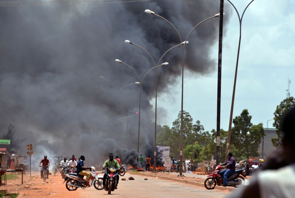 Residents burn tires along a street in Ouagadougou on September 17, 2015, after Burkina Faso's presidential guard declared a coup, a day after seizing the interim president and senior government members, as the country geared up for its first elections since the overthrow of longtime leader Blaise Compaore. (AFP Photo/Ahmed Ouoba)