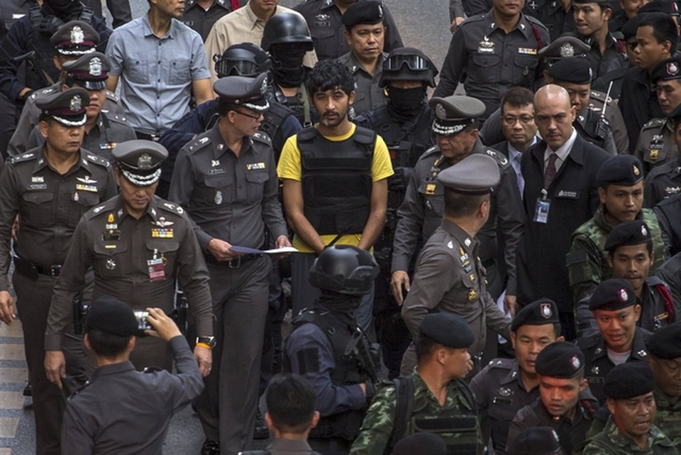 A suspect, center, of the Aug. 17 Bangkok blast who was arrested last week near the border with Cambodia walks with police officers during a crime re-enactment near the bomb site at Erawan Shrine in Bangkok, Thailand. (Reuters Photo/Athit Perawongmetha)
