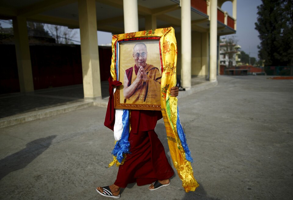 A Tibetan monk carries a portrait of exiled Tibetan spiritual leader, the Dalai Lama, during a function organised to mark "Losar" or the Tibetan New Year, in Kathmandu in this March 4, 2014 file photo. (Rfeuters Photo/Navesh Chitrakar)