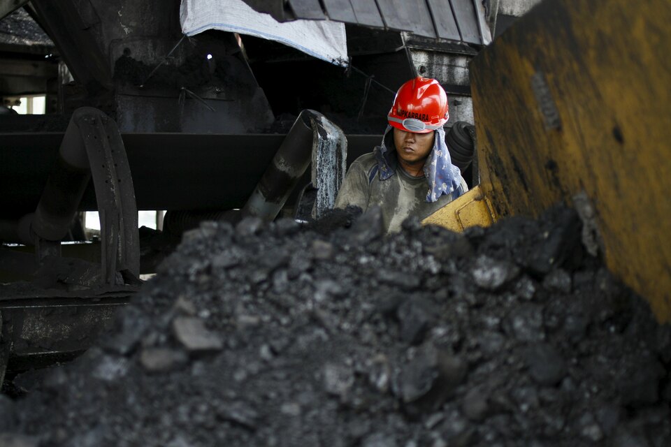 A worker of state-coal miner Bukit Asam cleans a conveyor belt at the Tarahan coal port in Lampung province in this Aug. 20, 2011 file photo. (Reuters Photo/Dwi Oblo)