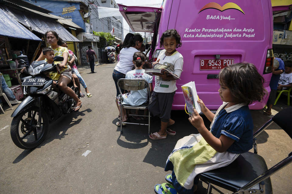 Kids reading books a mobile library in Central Jakarta on Oct. 11. (Antara Photo/Sigid Kurniawan)