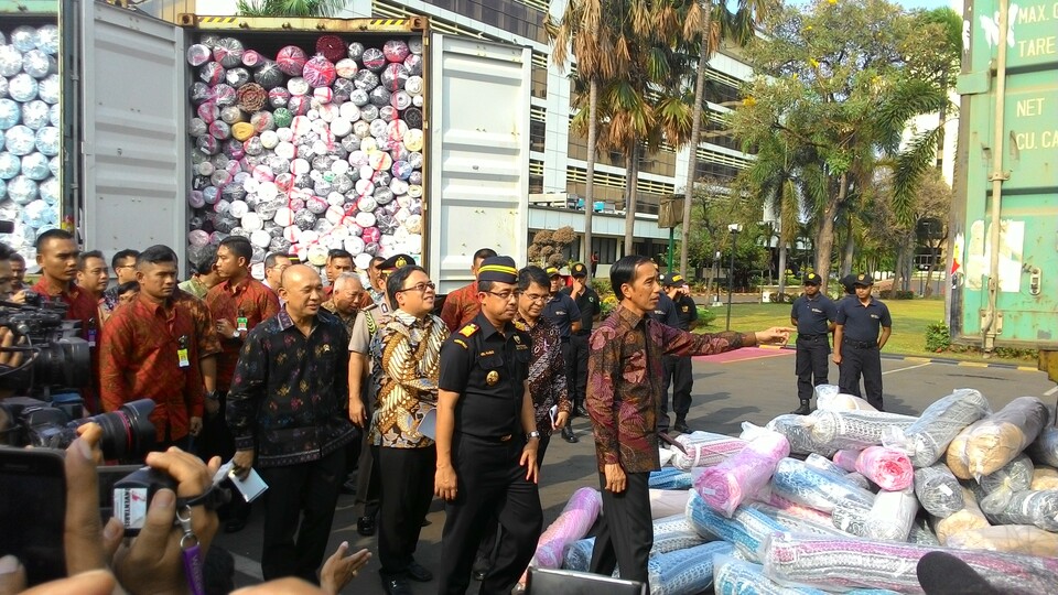 President Joko Widodo inspects seized shipments of illegally imported textiles at the customs and excise headquarters in Jakarta on Friday. (JG Photo/Priska Sari Pratiwi)