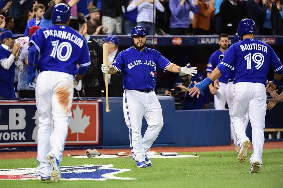 Dioner Navarro #30 of the Toronto Blue Jays celebrates a Troy Tulowitzki #2 double to score three runs with Edwin Encarnacion #10 and Jose Bautista #19 in the sixth inning during game five of the American League Championship Series at Rogers Center on October 21, 2015 in Toronto, Canada. 