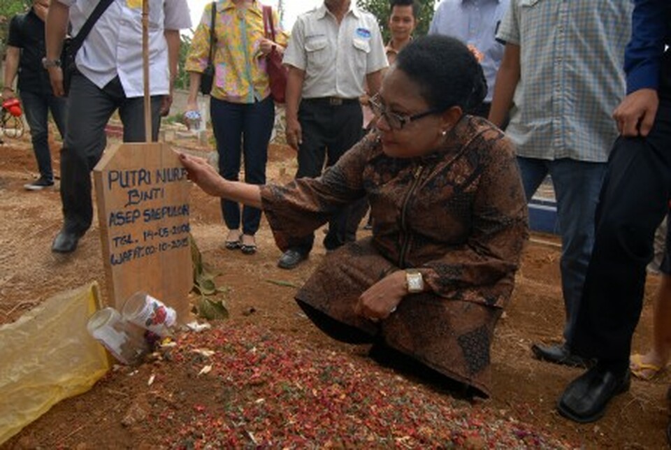 Women's Empowerment and Child Protection Minister Yohana Yembise pays her respects at the grave of Putri Nur Fauziah, a 9-year-old girl who was found murdered in West Jakarta earlier this year. (Antara Photo/Lucky R.)