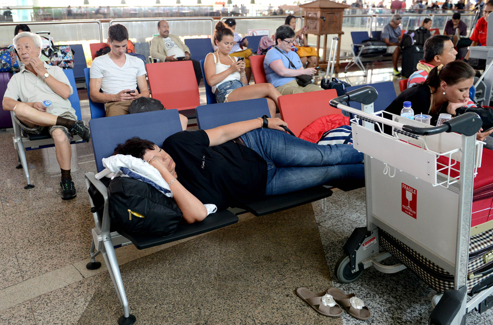 Passengers wait for information on delayed and cancelled flights at the international departure area of Bali's Ngurah Rai Airport in Denpasar on Thursday. (AFP Photo/Sonny Tumbelaka)