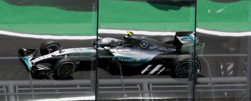 Mercedes Formula One driver Nico Rosberg of Germany is reflected in the windows while he powers his car during the third free practice of the Brazilian F1 Grand Prix in Sao Paulo on Saturday. (Reuters Photo/Paulo Whitaker)