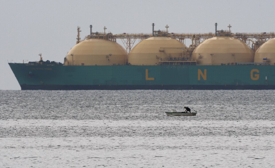 A fisherman stands in his boat as a liquid natural gas tanker (LNG) passes the coast near Havana in this June 28, 2009 file photo.  (Reuters Photo/Desmond Boylan)