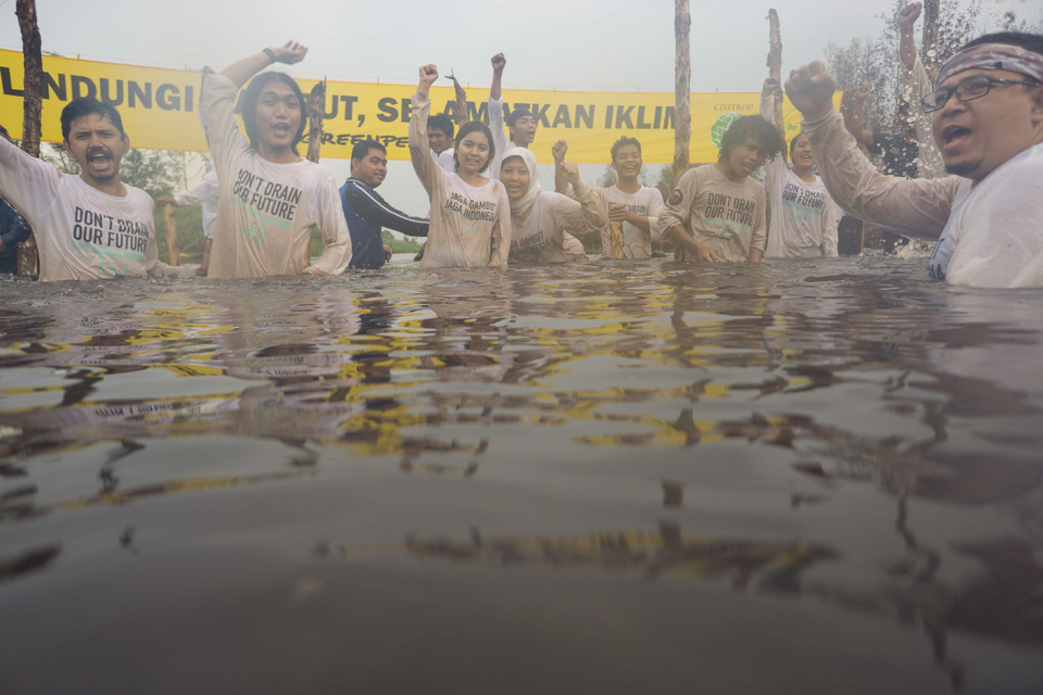 Residents and Greenpeace activists react after build a community dam to block a canal draining peatlands for plantations in Paduran Village, Sebangau Sub-district, Pulang Pisau Regency, Central Kalimantan province, Indonesia. (JG Photo/Greenpeace/Ardiles Rante)