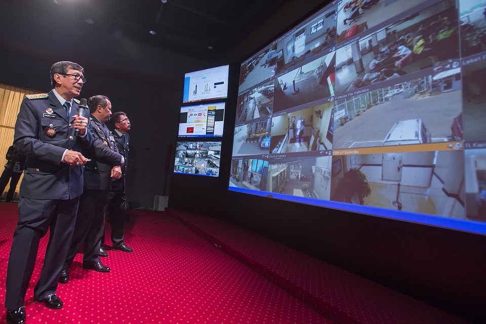 FILE - In this Oct. 15, 2015 photo, Justice Minister Yasonna Laoly, left, inspects a bank of CCTV monitors showing live feeds from prisons across the country, at the ministry building in South Jakarta. (Antara Photo/Widodo S. Jusuf)
