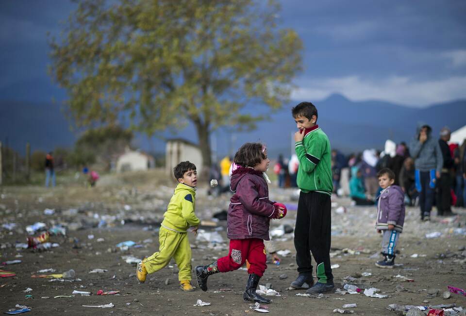 Children play with a ball as they wait with other migrants and refugees to enter a registration camp after crossing the Greek-Macedonian border near Gevgelijaon November 22, 2015. Serbia and Macedonia, which lie on the main migrant route to northern Europe, have begun restricting the entry of refugees to just those from certain countries, the UN refugee agency said on November 19. (AFP Photo/Robert Atanasovski)