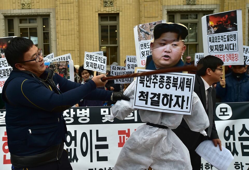A South Korean conservative activist strikes an effigy of North Korean leader Kim Jong-Un (R) during an anti-North Korea rally to commemorate the 5th anniversary of North Korea