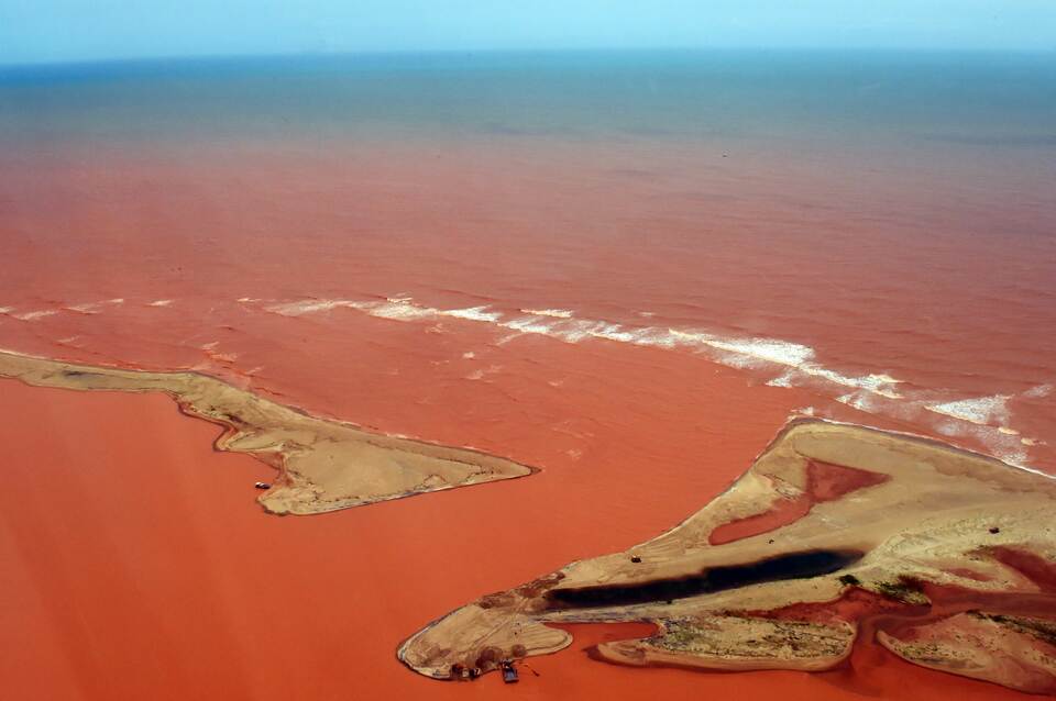An aerial view of the Doce River--which was flooded with toxic lama after a dam owned by Brazilian Vale SA and Australian BHP Billiton Ltd burst early this month-- flowing into the Atlantic Ocean in Regencia, Espirito Santo State, Brazil, on November 24, 2015. (AFP P{hoto/Fred Loureiro)