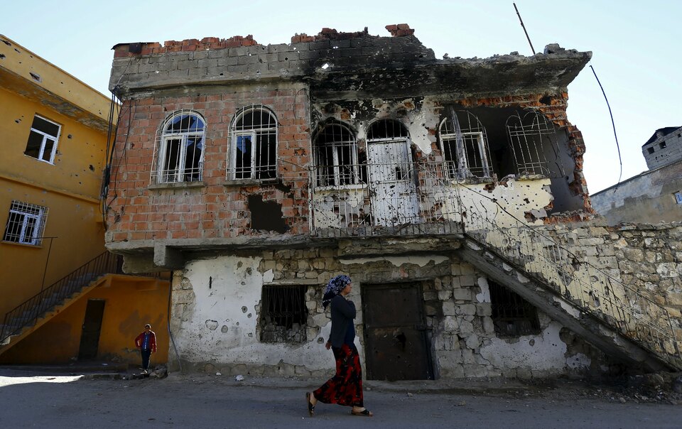 A woman walks past a building that was damaged during clashes between Turkish security forces and Kurdish militants, in the southeastern town of Silvan in Diyarbakir province, Turkey, on Dec. 7. (Reuters Photo/Murad Sezer)