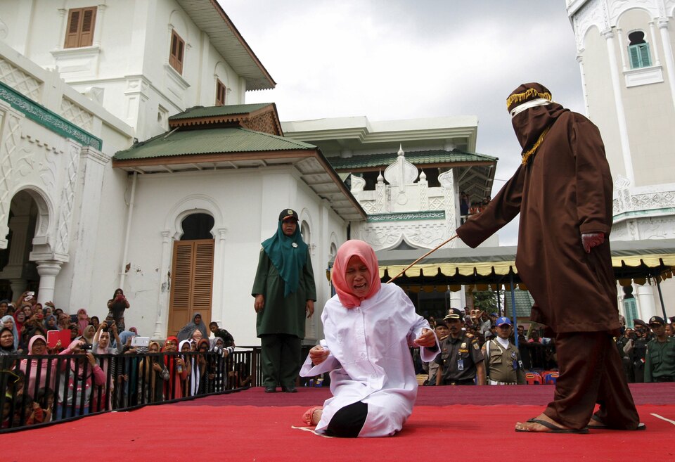 An Acehnese woman screams during caning as part of her sentence in the courtyard of the Baiturrahman Mosque in Banda Aceh. (Reuters Photo/Junaidi Hanafiah)  