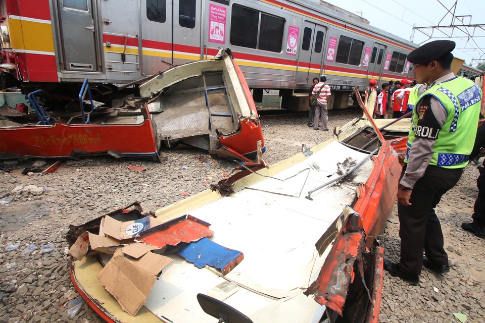 Eighteen people are dead and six injured after a MetroMini bus was struck by a train in West Jakarta on Sunday morning, the second such incident in just over a week. (Antara Photo/Rivan Awal Lingga)