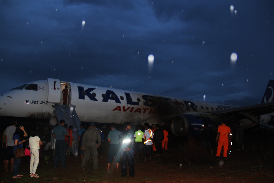 Passengers disembark from the Kalstar plane after it skidded off the runway at the airport in Kupang, East Nusa Tenggara, on Monday. (Antara Photo/Kornelis Kaha)