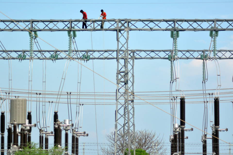 Workers from state utility firm Perusahaan Listrik Negara (PLN) perform maintenance on a relay station in Sidoarjo, East Java, on Tuesday. (Antara Photo/Umarul Faruq)