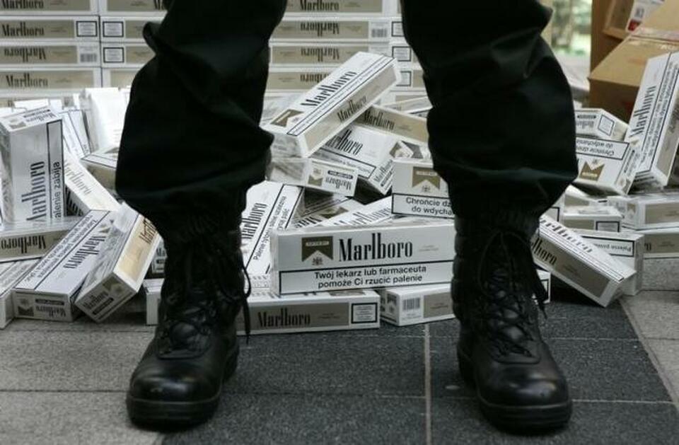 A German customs officer stands in front of confiscated cigarettes before the customs annual news conference in Munich March 13, 2007.  (Reuters Photo/Michaela Rehle)