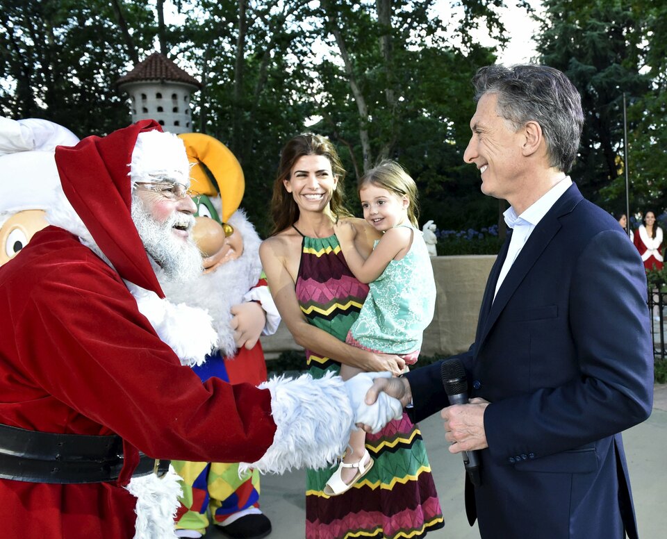 President Mauricio Macri (R) shakes hands with Santa Claus as his wife Juliana Awada and their daughter Antonia smile at the Olivos presidential residence in Buenos Aires, Argentina, December 23, 2015 in this handout provided by Argentine Presidency. REUTERS/Argentine Presidency/Handout