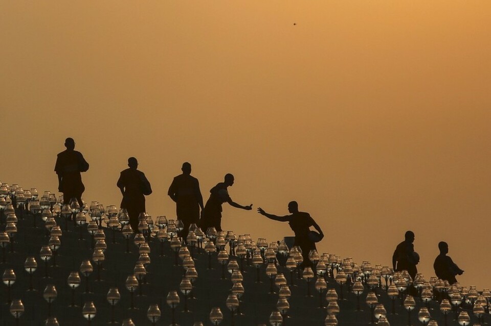 Buddhist monks prepare for an alms offering ceremony at the Wat Phra Dhammakaya temple in Pathum Thani province, north of Bangkok as the sun rises on Makha Bucha Day, in this March 4, 2015 file photo. (Reuters Photo/Damir Sagolj)
