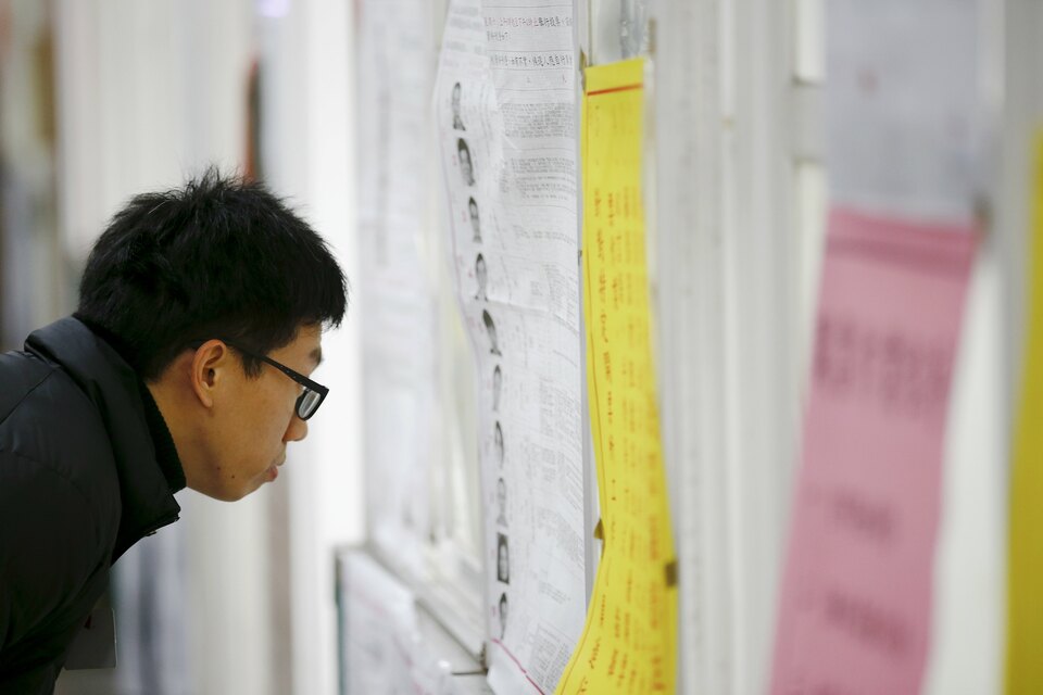A man studies election lists at a polling station inside a school during general elections in Taipei, Taiwan January 16, 2016. (Reuters Photo/Damir Sagolj)