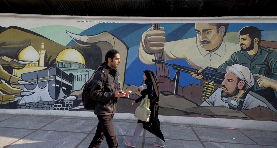 Iranians walk past a revolutionary mural in Tehran, Iran, January 17, 2016. (Reuters Photo/Raheb Homavandi)