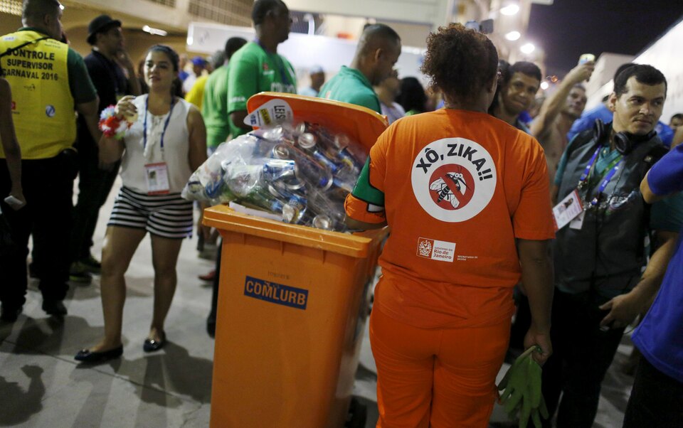 A worker from a public cleaning company wears a T-shirt that reads, "Out Zika " as she collects garbage during the carnival parade at the Sambadrome in Rio de Janeiro, February 9, 2016. (Reuters Photo/Pilar Olivares)
