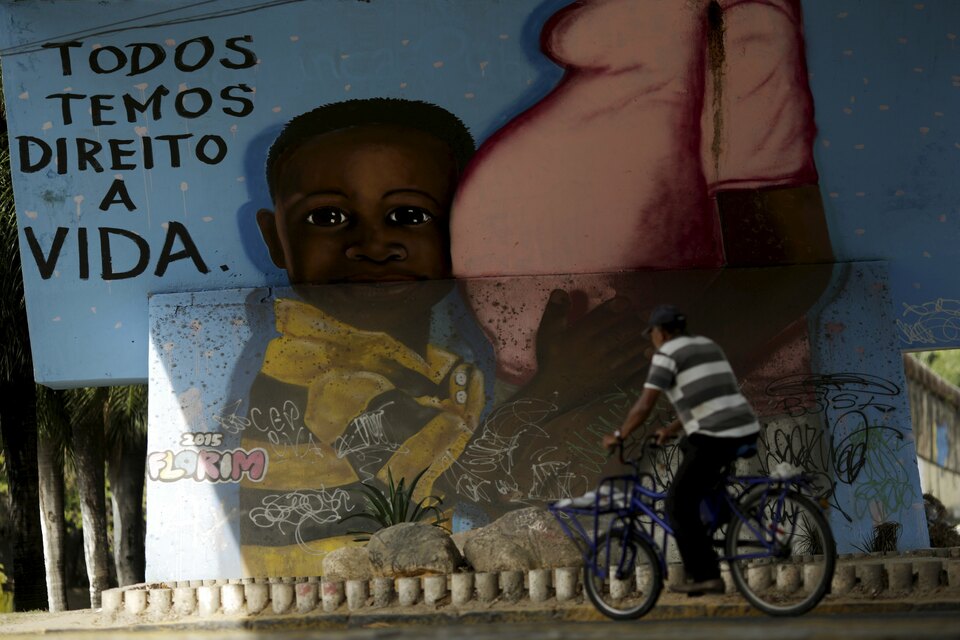 A man walks in front of a graffiti of pregnancy on an overpass in Recife, Brazil, February 4, 2016. (Reuters Photo/Ueslei Marcelino)