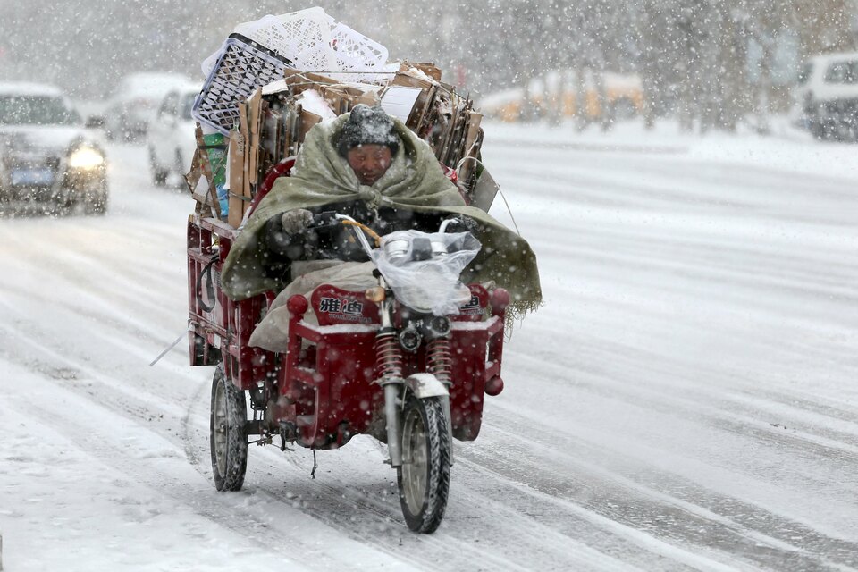 A man rides a motorcycle along a street in the snow in Altay, China's Xinjiang Uighur Autonomous region, on Tuesday (09/02). (Reuters Photo)