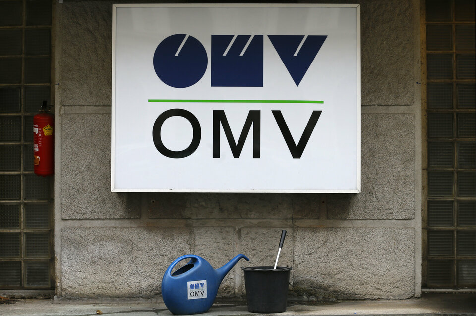 Watering cans in front of the logo of Austrian energy group OMV at a gas station in Vienna, Austria, Feb. 17, 2016. (Reuters Photo/Heinz-Peter Bade)