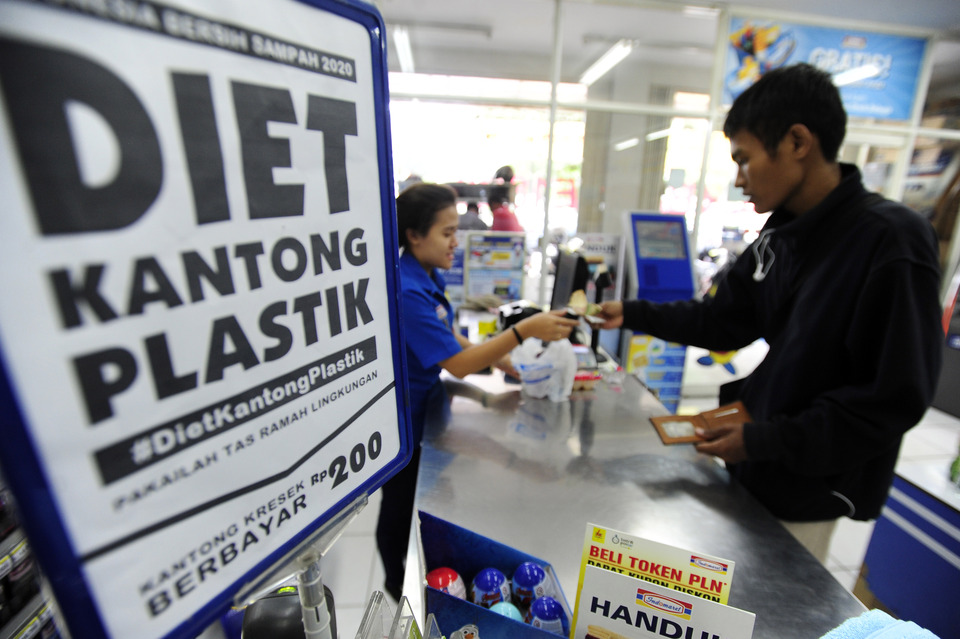 A customer pays for his purchases at a mini market in Pasar Baru, Jakarta, on Feb. 21. A legislator in Ambon, Maluku province, has criticized the central government's implementation of the new policy that requires businesses to charge for plastic shopping bags, saying that it has led to confusion and discrepancies. (Antara Photo/Wahyu Putro A)