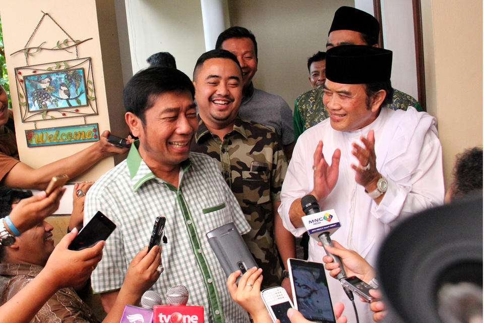Abraham 'Lulung' Lunggana, left, speaks to the media outside the home of Idaman Party chairman and dangdut singer Rhoma Irama, right, in Mampang Prapatan, South Jakarta, on Friday (18/03). Lulung visited Rhoma in a in a bid to seek his support for his candidacy in next year’s Jakarta gubernatorial election. (Antara Photo/Fauziyyah Sitanova)