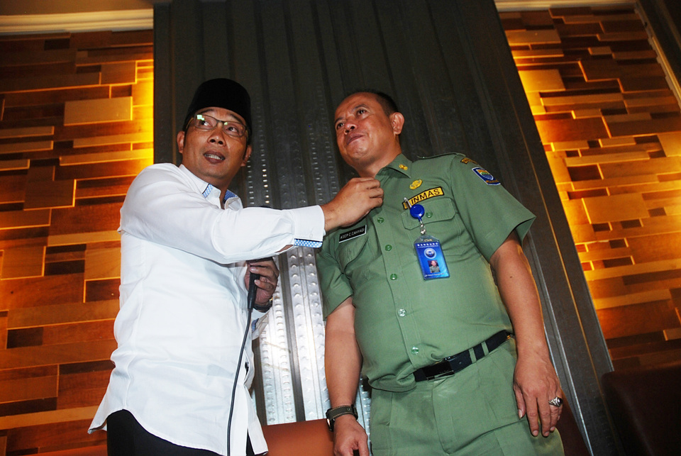 Mayor Ridwan Kamil demonstrating to reporters on Monday (21/03) what he claimed he did to a man caught providing illegal transportation in Bandung. (Antara Photo/Fahrul Jayadiputra)