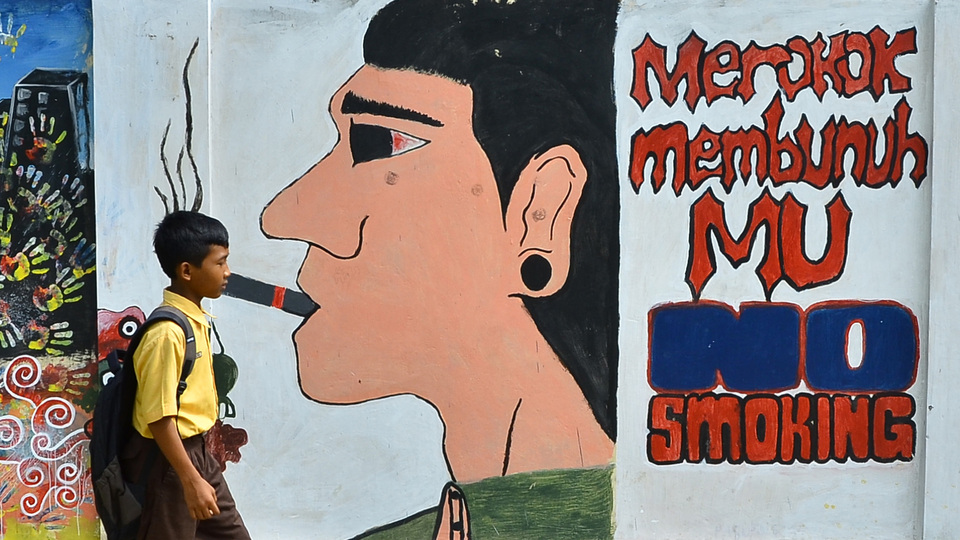 A boy walks past an anti-smoking mural in Grobogan, Central Java, in 2016. (Antara Photo/Yusuf Nugroho)