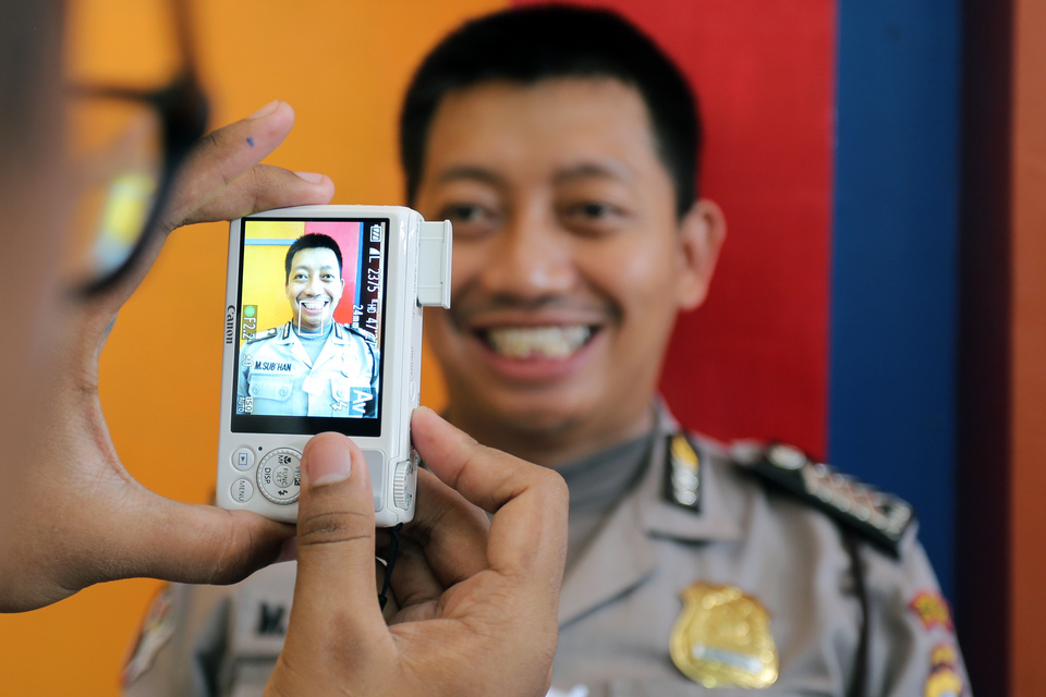 A policeman poses for a photograph during a medical checkup at the Blitar Police headquarters in East Java in March 2016. (Antara Photo/Irfan Anshori)