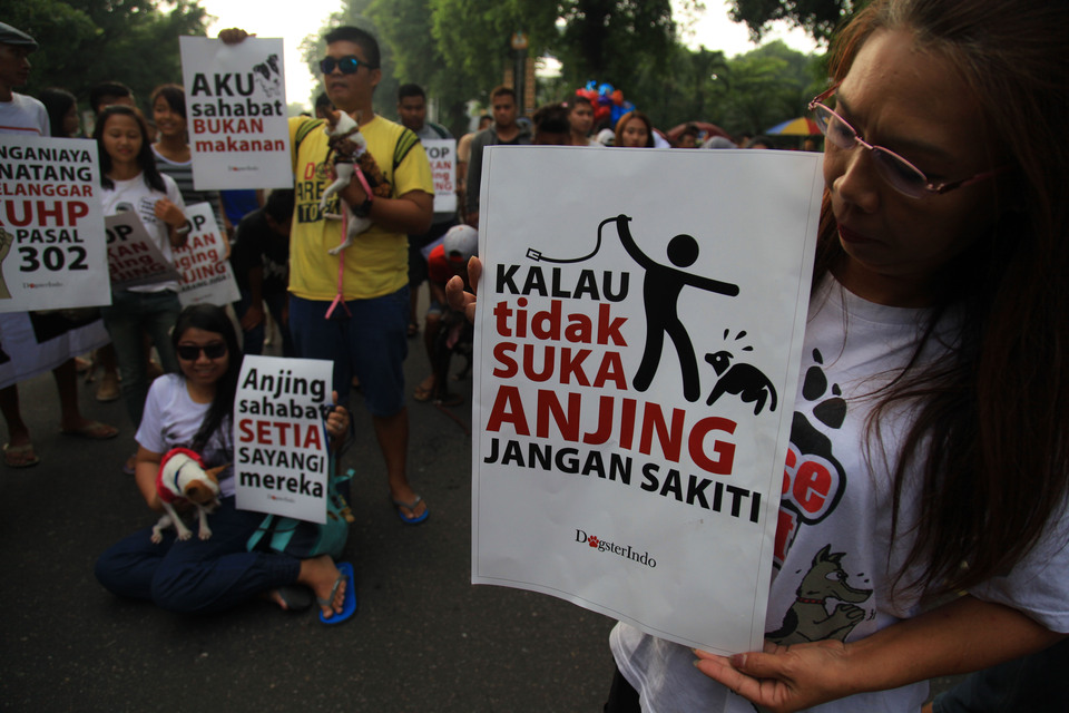 Activists hold up posters urging people not to hurt animals and to stop eating dog meat during a campaign in Jalan Slamet Riyadi in Solo, Central Java, on Sunday (06/03). (Antara Photo/Maulana Surya)