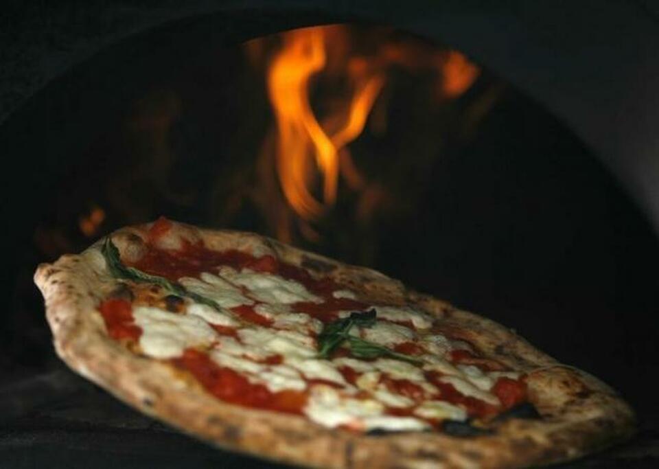 A pizza is removed from a wood-burning oven, in this file photo in Naples, Aug. 27, 2008.  (Reuters Photo/Ciro De Luca/Agnfoto)