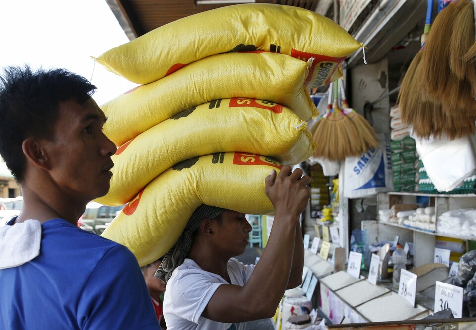 A man carries on his head sacks of rice at a food market in Paranaque, Metro Manila Philippines. (Reuters Photo/Erik De Castro)